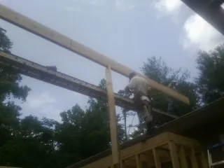 Carpenter setting a ridge beam over a new addition frame — Ice Dam Removal by Roofing Brothers in Scribner