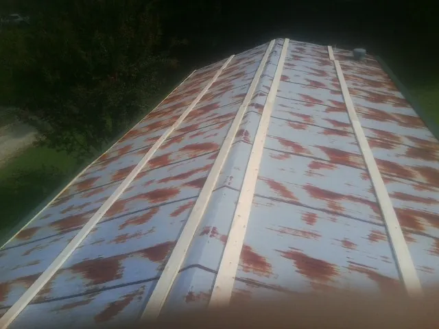 Rusted metal roof panels with new wood purlins before replacement — Storm Damage Roof Repair in Scribner by Roofing Brothers