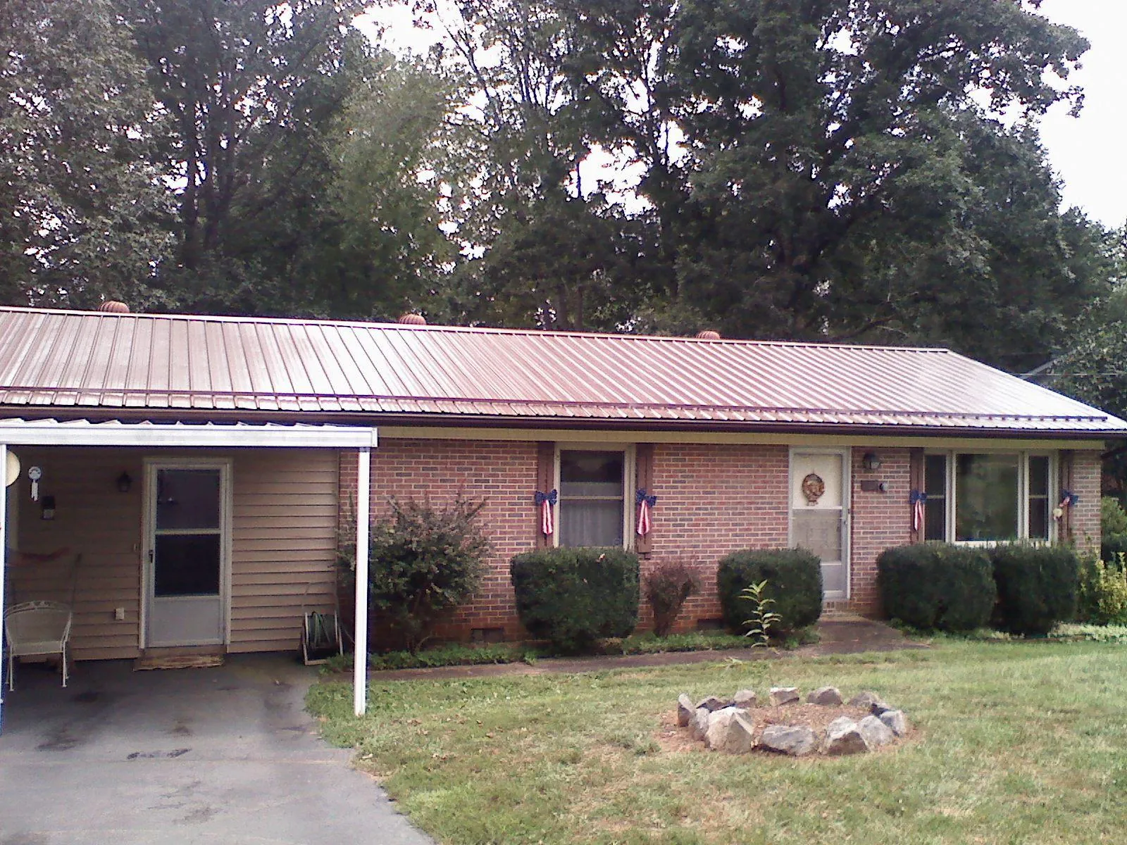 Bronze metal roof and carport on a brick ranch home — Roof Repair work by our crew in Scribner